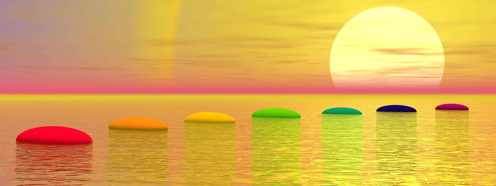 Seven chakra-colored stones arranged on calm water at sunset, evoking vibration and balance.