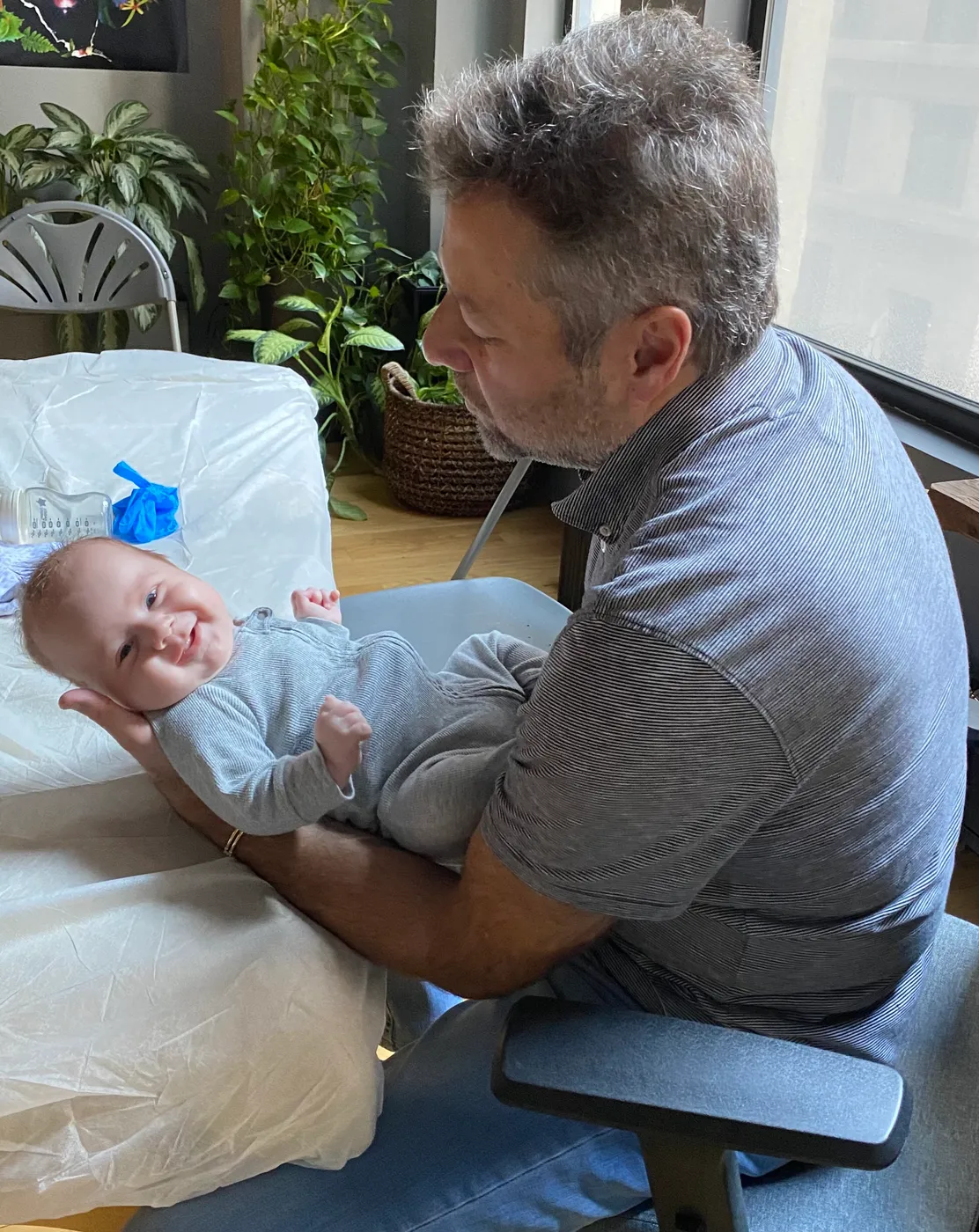 Dr. Alex Kaminsky treating a smiling infant during a craniosacral therapy session in his Manhattan office.