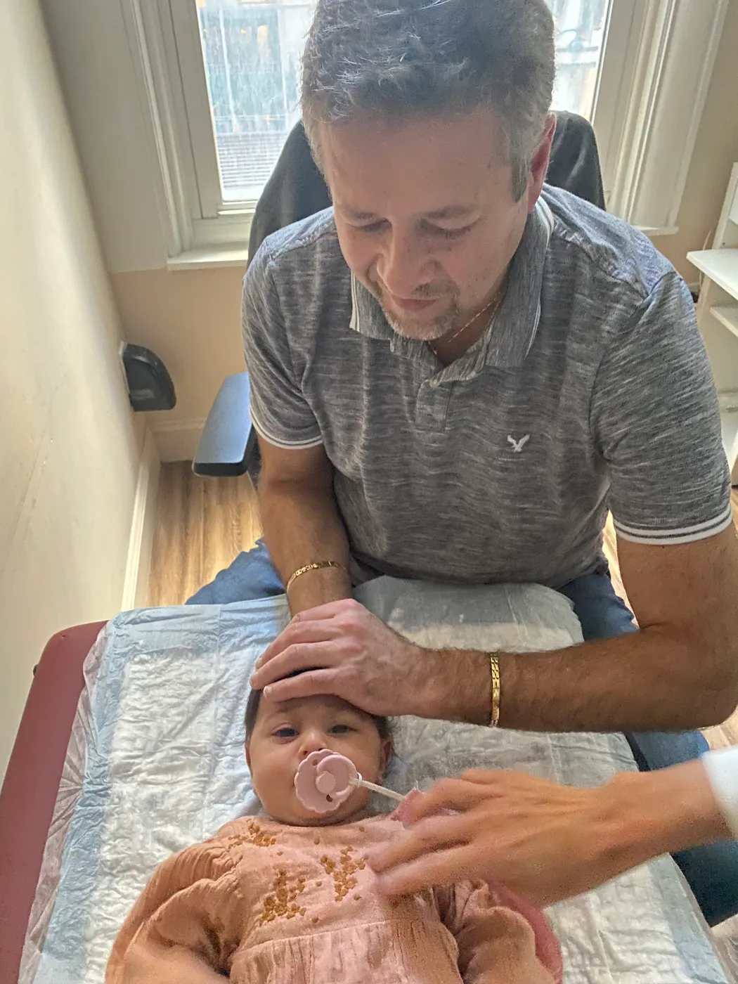Dr. Alex Kaminsky cradling a baby's head during pediatric craniosacral therapy.